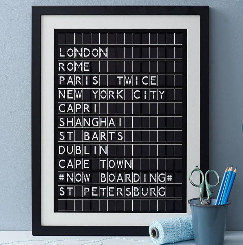Black framed black and white print in the style of an airport departures board