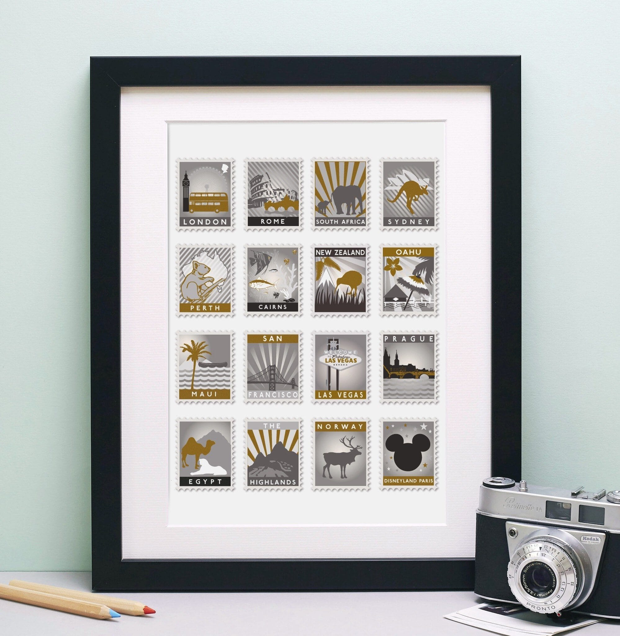 Black framed print with 16 monochrome and gold toned stamp designs on a white background.