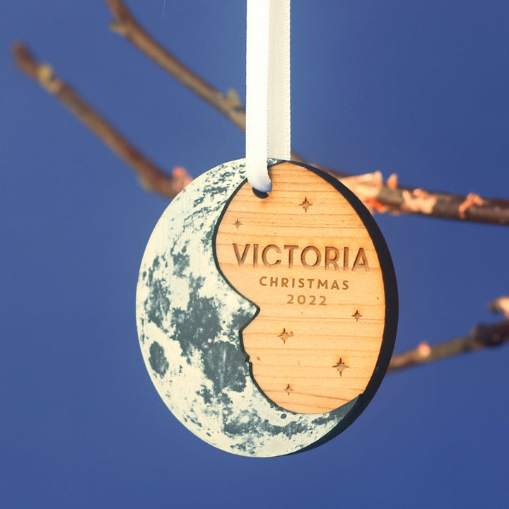 Wooden round Christmas tree decoration with a silver crescent  moon and personalised text. Perfect for baby's first Christmas