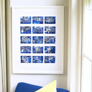 White framed print with 15 small blue maps of different locations