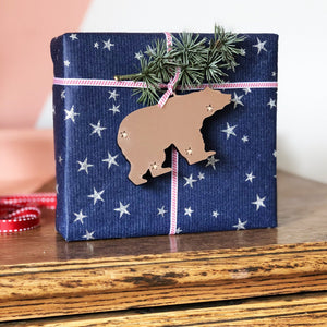 Metallic polar bear decoration being used as a gift tag on a present