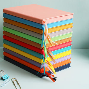 Stack of coloured notebooks showing the matching ribbon markers and the matching coloured edges.