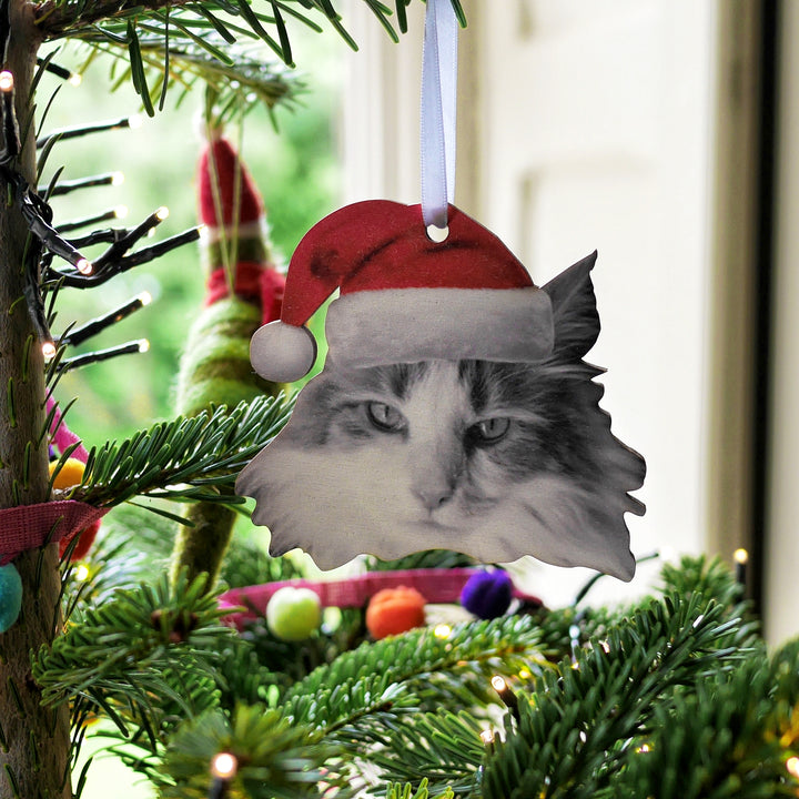 personalised custom bauble Christmas decoration of a cat wearing a Santa hat hanging from a satin white ribbon. 