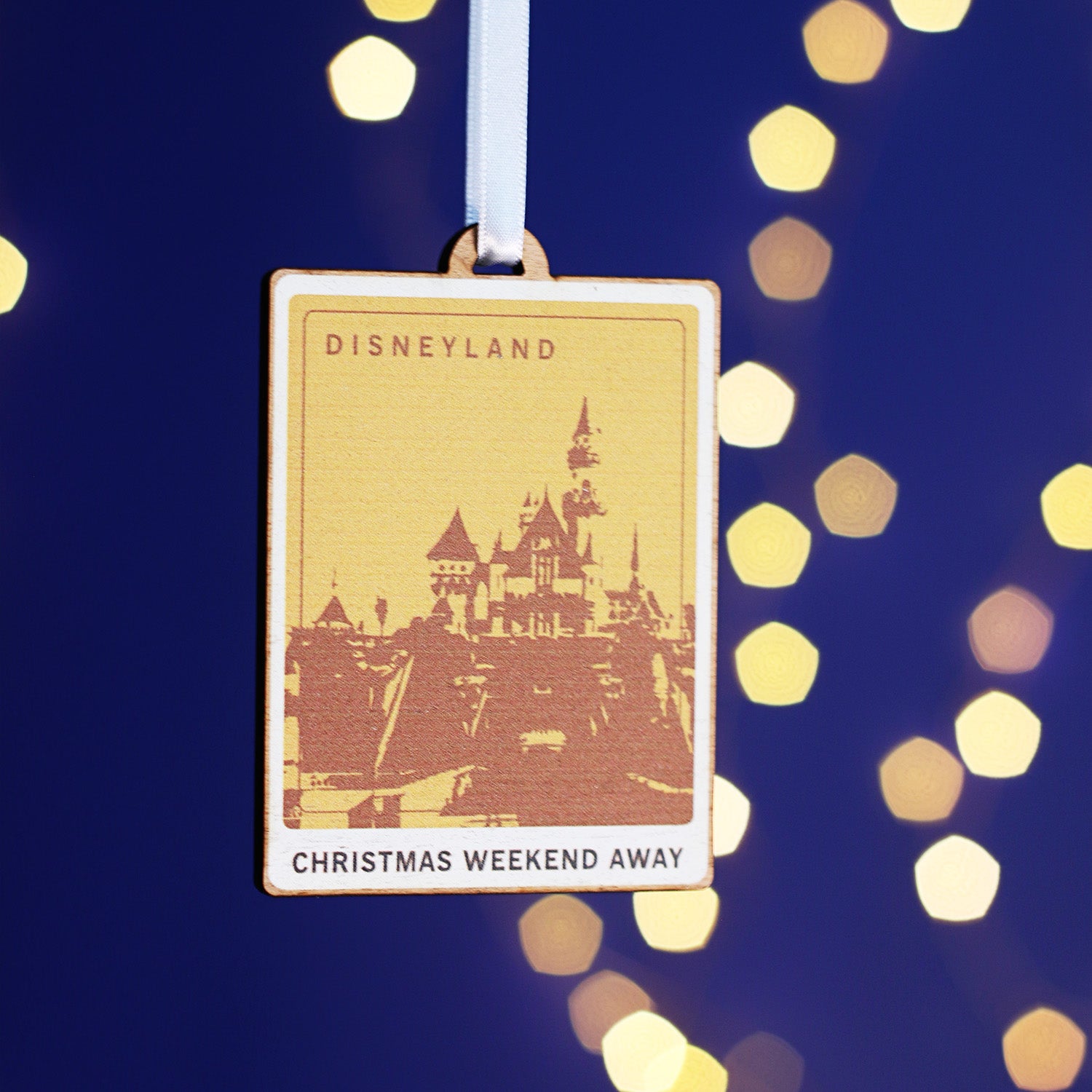 Wooden Christmas decoration with a picture representing Disneyland printed on it.