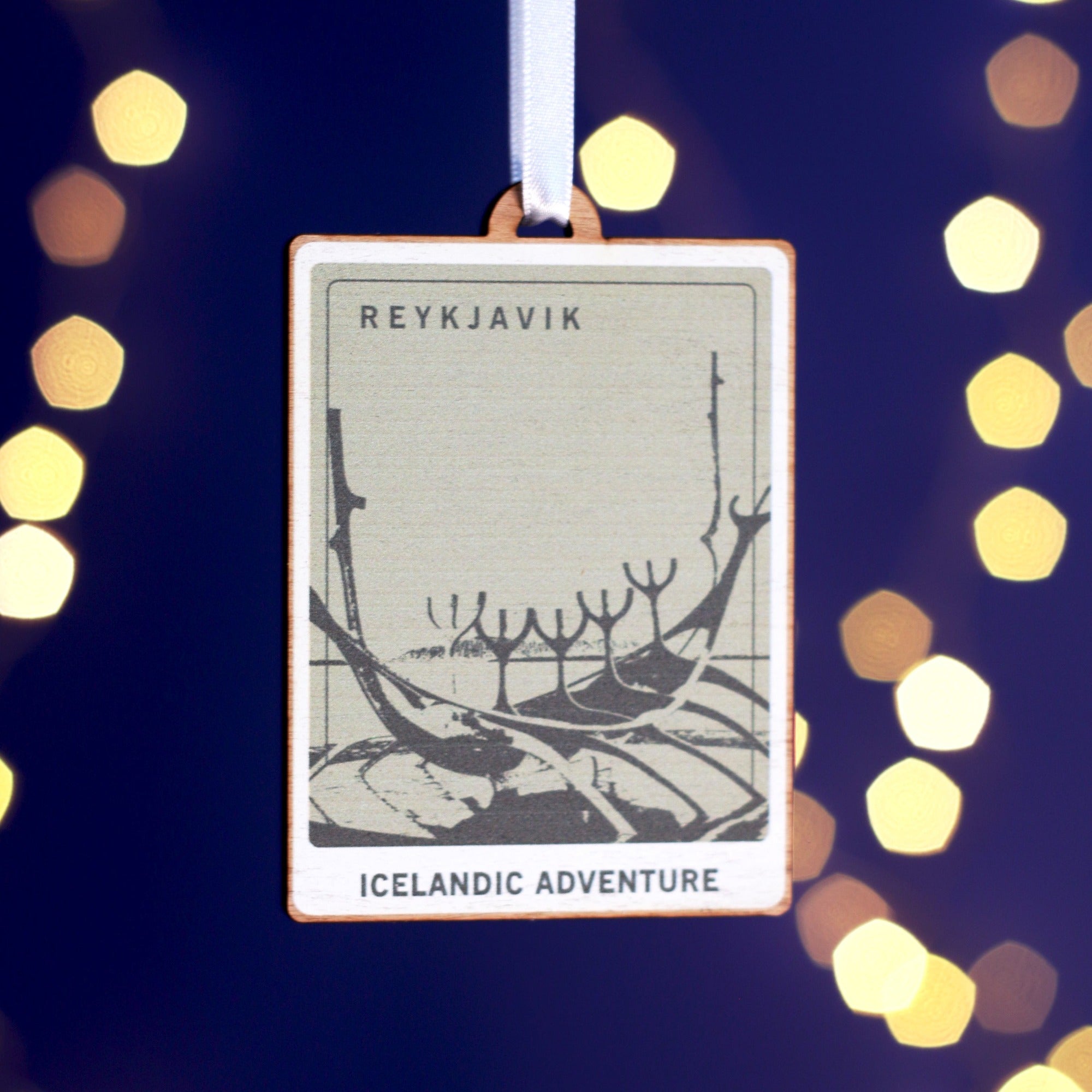 Wooden Christmas decoration with a picture representing Reykjavik printed on it.