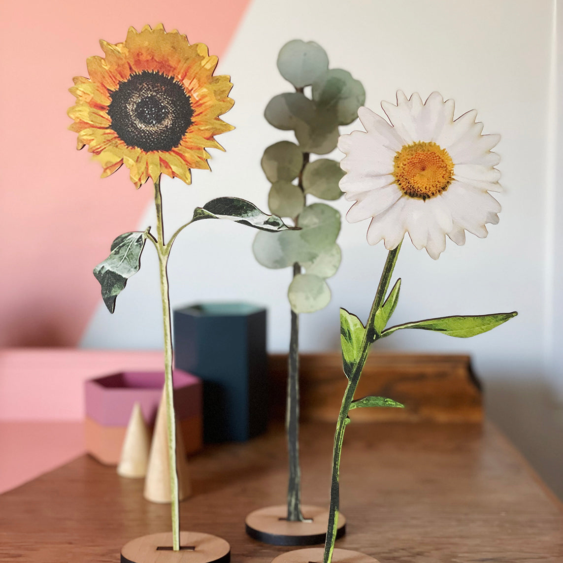 Display of a wooden sunflower, daisy and eucalyptus leaves